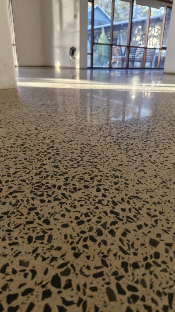 Polished aggregate concrete floor reflecting light in a modern home.
