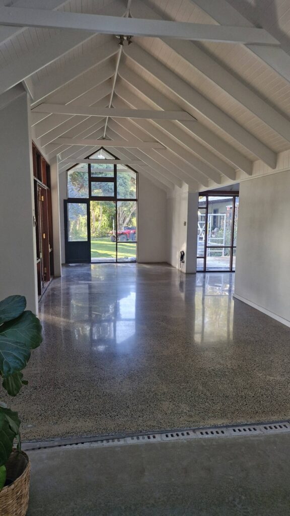 Polished concrete floor reflecting light in a vaulted room.
