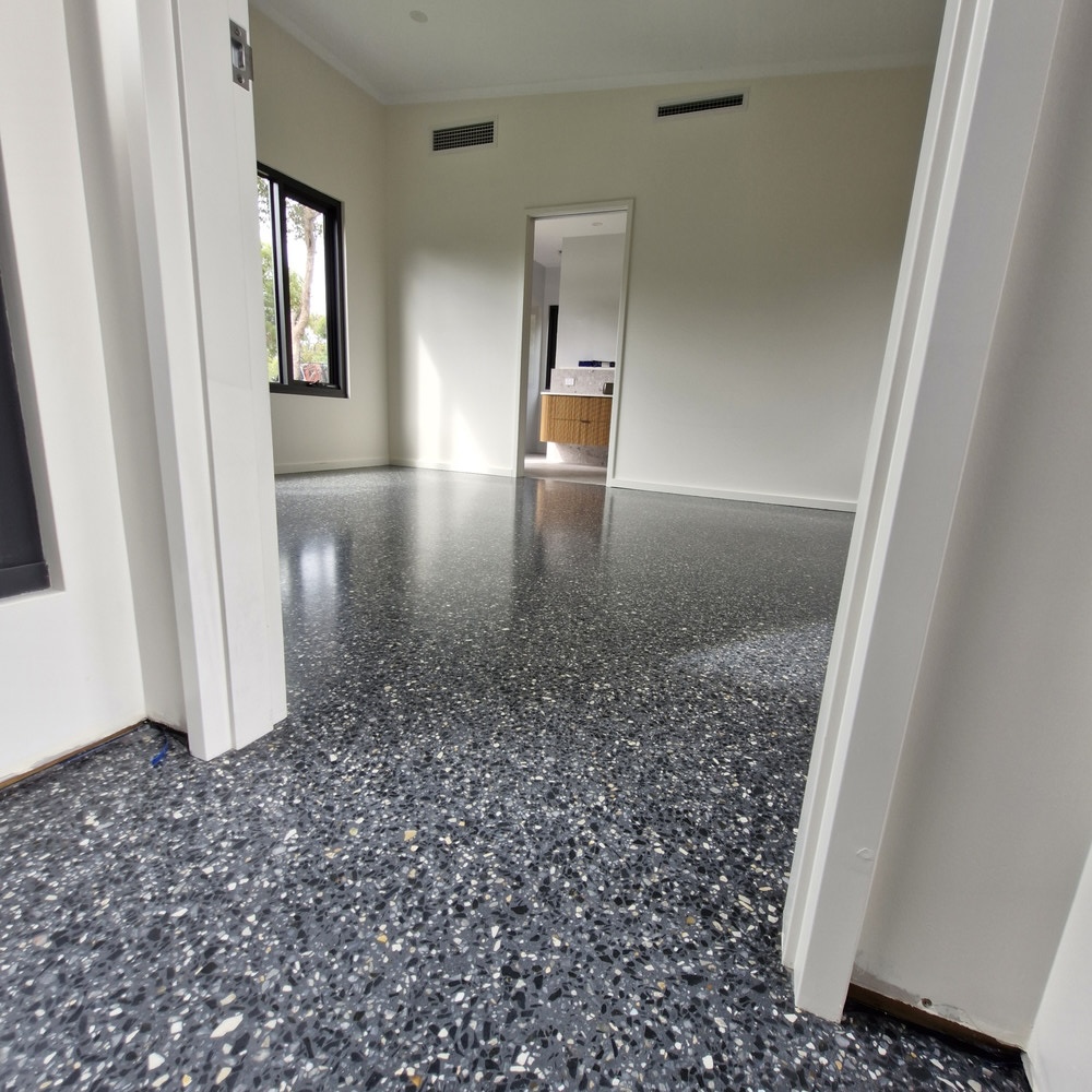 High-gloss dark grey terrazzo flooring in a modern home.