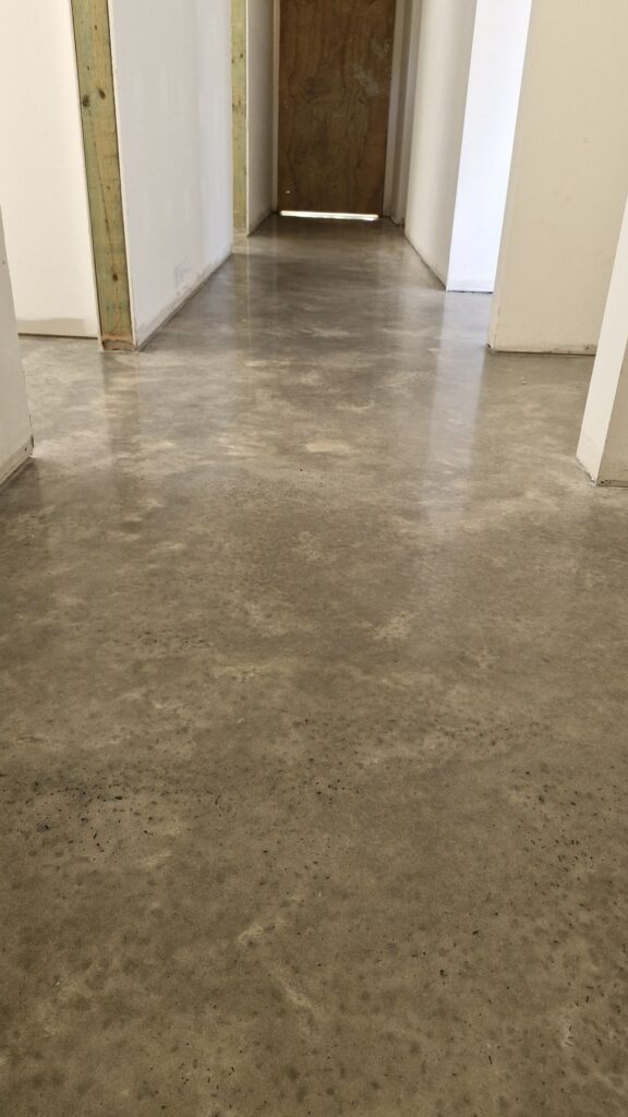 Polished concrete floor in a modern hallway under construction.